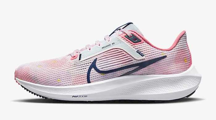 Side view of pink and navy Nike shoe.